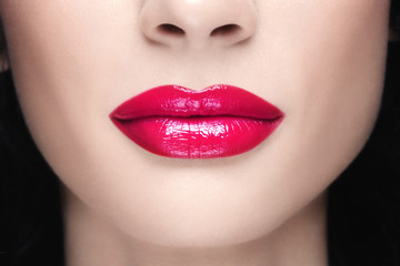 Fototapeta premium Close-up shot of woman lips with glossy fuchsia lipstick
