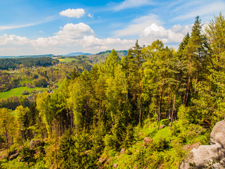 Summer time landscape with green forest, sandstone rocks and blue sky with white clouds, Bohemian Paradise, aka Cesky Raj, Czech Republic, Europe.