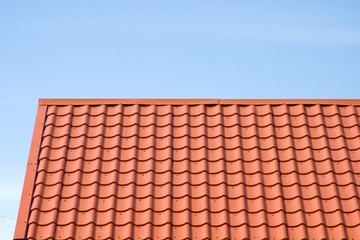 Red roof of metal roofing on the sky background