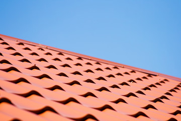 Red roof of metal roofing on the sky background