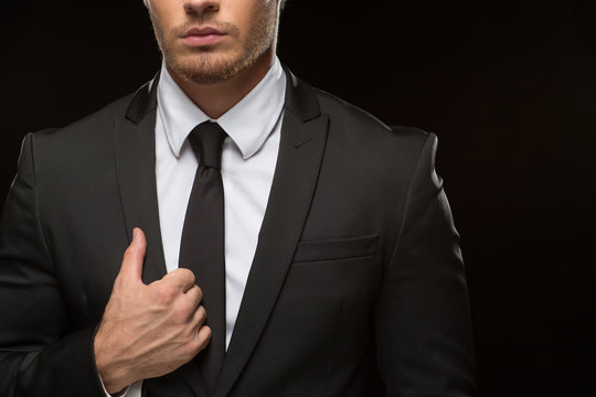 Serious handsome businessman in a suit on black background
