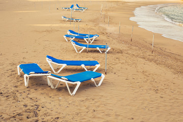 Fototapeta na wymiar Sunbeds on the sea beach, top view