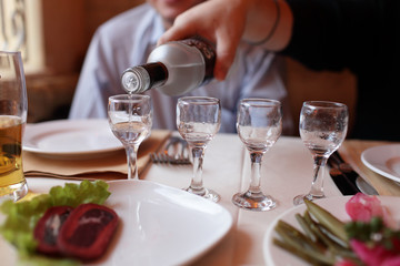 Filling glasses of vodka