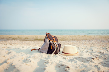 Fototapeta na wymiar Vintage bag and straw hat lying on the beach on a background of the sea