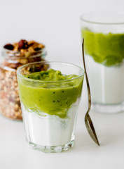 Green vegetarian Smoothie with Antioxidants, granola, kiwi, avocado strawberry for breakfast or lunch on white background. Healthy-woman food concept