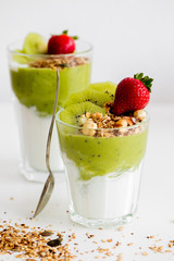 Green vegetarian Smoothie with Antioxidants, granola, kiwi, avocado strawberry for breakfast or lunch on white background. Healthy-woman food concept