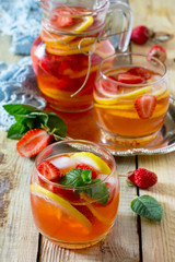 Refreshing summer drink strawberry mojito on a wooden table. The concept of eating vegetarians, fresh vitamins, homemade refreshing fruit drink.