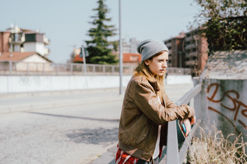 Young beautiful woman lenaing outdoor in the city looking away thoughtful - getting away from it...