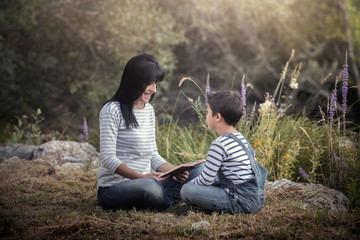 madre con un libro junto a su hijo