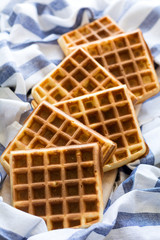 Fresh homemade belgian waffles on striped napkin. Selective focus