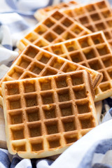 Fresh homemade belgian waffles on striped napkin. Selective focus