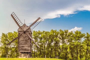 Papier Peint photo Moulins Large Russian wooden windmill on a background of green trees. Summer landscape.