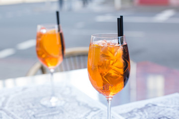 Aperol Spritz Cocktail. Alcoholic beverage based on table with ice cubes and oranges.