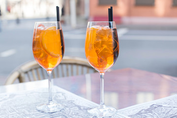 Aperol Spritz Cocktail. Alcoholic beverage based on table with ice cubes and oranges.