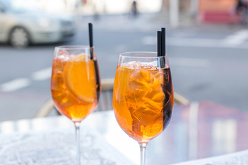 Aperol Spritz Cocktail. Alcoholic beverage based on table with ice cubes and oranges.