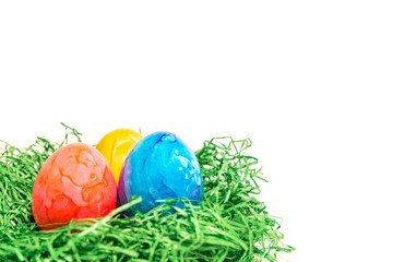 Osterei in einem Osternest aus grünem Gras mit weißem Hintergrund