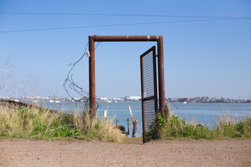 Abandoned damaged rusted gate with razor wire on a seasideat Isle of Sheppey England United-Kingdom 