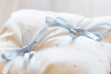 gold wedding rings on satin pillow