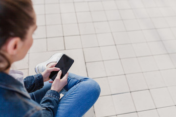 Close-up of female hands using modern smart phone, outside in daylight. Girl typing text message on her cellphone.