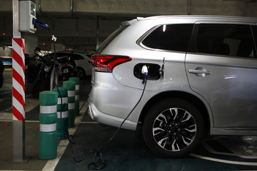 Fototapeta premium Plug-in-Hybrid mit Strom betanken im Parkhaus