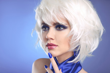 Blue makeup. Blonde bob hairstyle. Blond hair. Fashion Beauty Girl portrait. Sexy lips. Manicured nails and Make-up. Vogue Style Woman isolated on blue background.