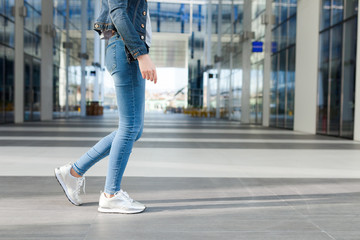Detail of a woman's legs, wearing jeans, dynamic view. Outdoor concept for modern outdoor or...