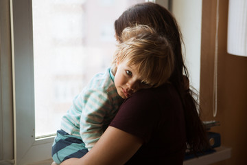 the sad kid on hands at his mother