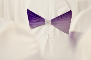 violet bow on a white wedding chair in the banquet room