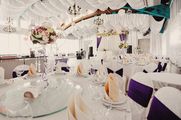 holiday wedding table in white and violet tones with compositions of flowers