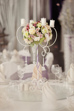 holiday wedding table in white tones with compositions of flowers and candles