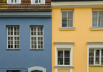 Obraz premium Two neighboring old houses. The houses are painted in yellow and blue colors. City of Riga. Latvia.