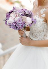 Bride with a beautiful purple wedding bouquet
