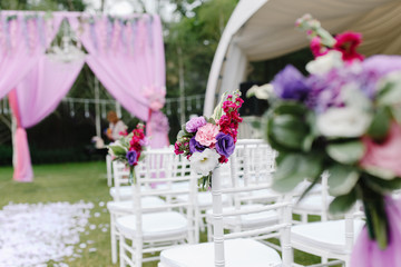 Outdoors wedding decoration with rose and peony bouquets