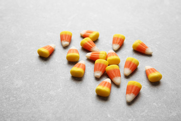 Tasty Halloween candies on light background