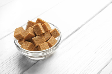 Brown sugar in bowl on wooden table