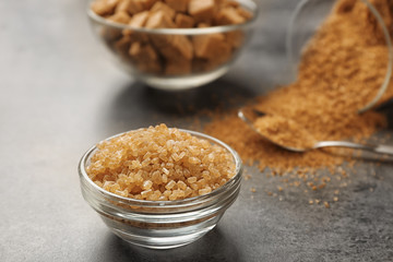 Bowl of brown sugar on gray background