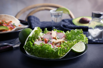 Plate of delicious taco with tequila lime chicken and vegetables on table