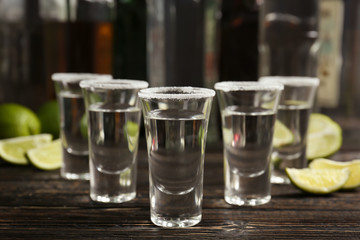 Tequila shots with lime slices and salt on table