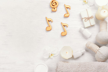 Beautiful composition of spa accessories and musical notes on white wooden background