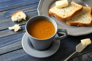Composition with tasty butter coffee and toasts on wooden table