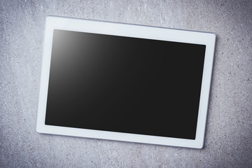 Overhead shot of digital tablet on gray stone background