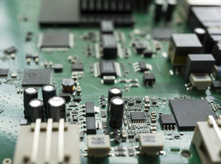 Fototapeta na wymiar Detail of an electronic printed circuit board with many electrical components with swallow depth of field.