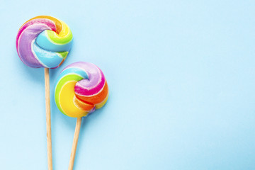 two rainbow color lollipops on blue background