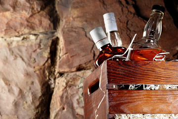 Bottle of whiskey. In a wooden conteainer for transporting, box with wooden chips. Stone background.copy space