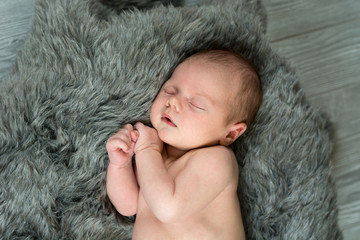 Newborn baby boy laying on fur