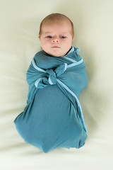 Newborn baby boy swaddled
