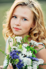 Fototapeta premium Portrait of a curly girl with flowers