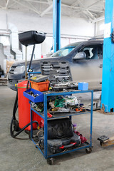 Stupino, Moscow region, Russia - April, 4, 2017: Interior of a car repair station in Stupino, Russia. There is a device for oil changing and tool's trolley on the frontground