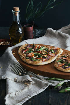 Pizza mit Stremellachs, Spargel und Pinienkernen: selbstgemachter Teig, rote Zwiebel, Frischk&auml;se mit Cayenne Pfeffer, Chilf&auml;den. Fotografiert mit Blende 8. 