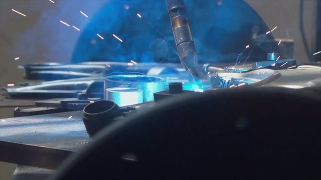 CU shot of robot arm welding car part on a factory. Industrial process, no people. 4K UHD 60 FPS